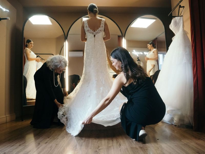 Bridal fitting with the wedding gown hem being adjusted